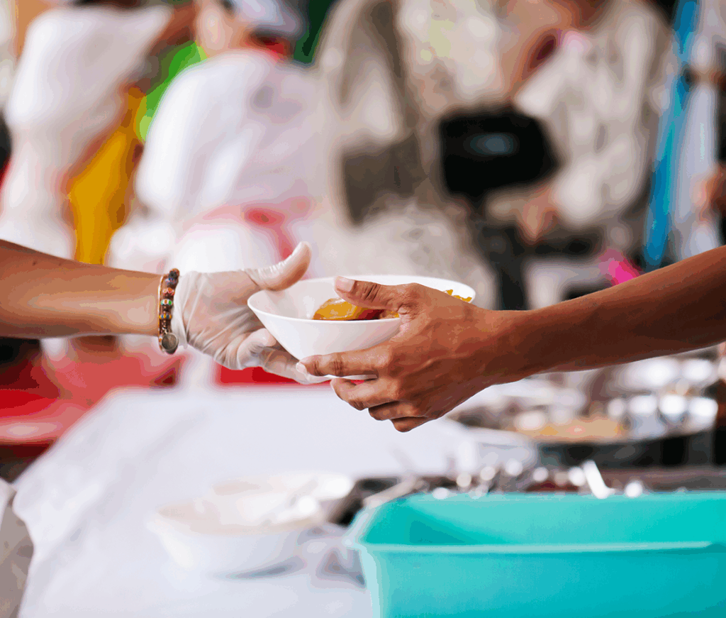 Person serving food in a bowl to another person.